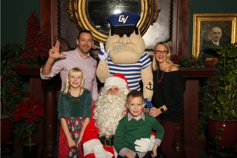Louie and Santa posing with alumni family of four